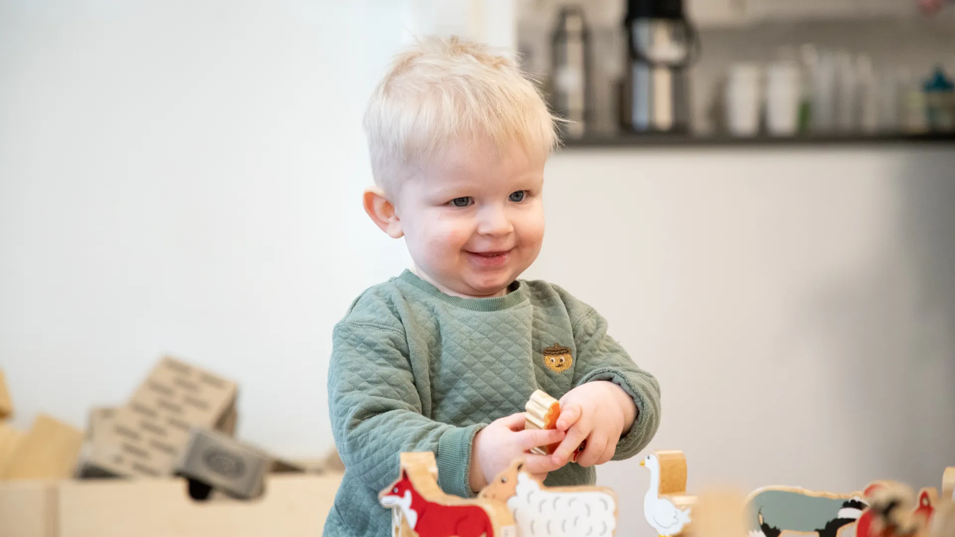 En liten pojke som står framför ett bord.