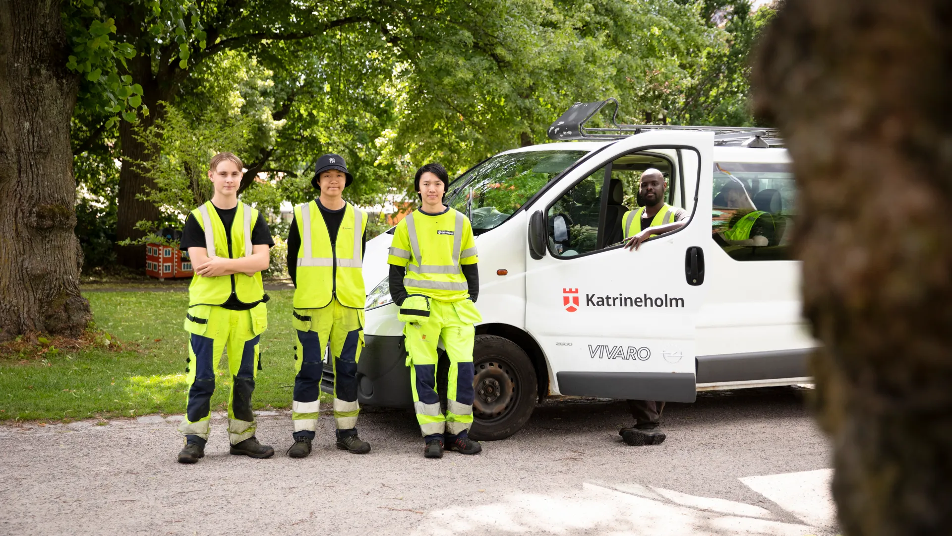 En grupp män som står bredvid en vit skåpbil.