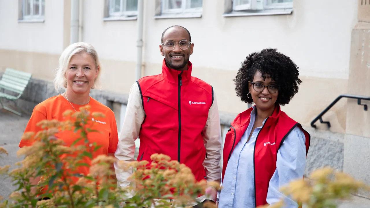 En grupp på tre personer som står bredvid varandra.