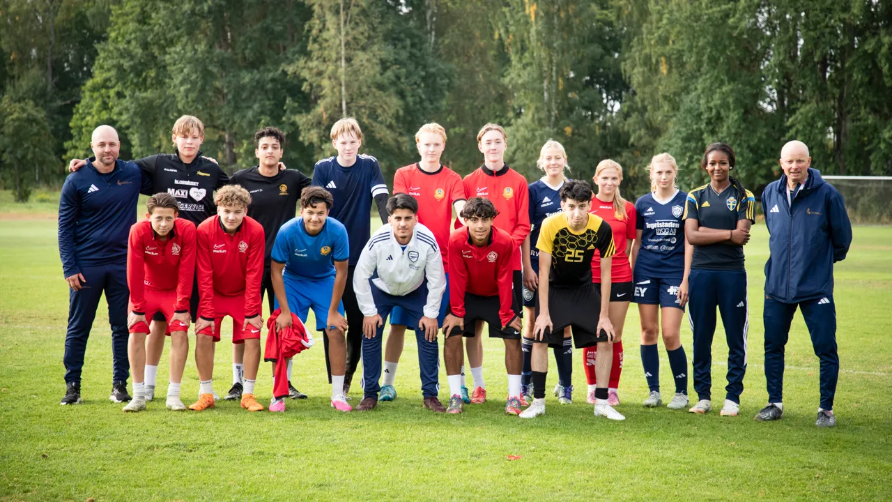 En grupp människor som står bredvid varandra på en äng.
