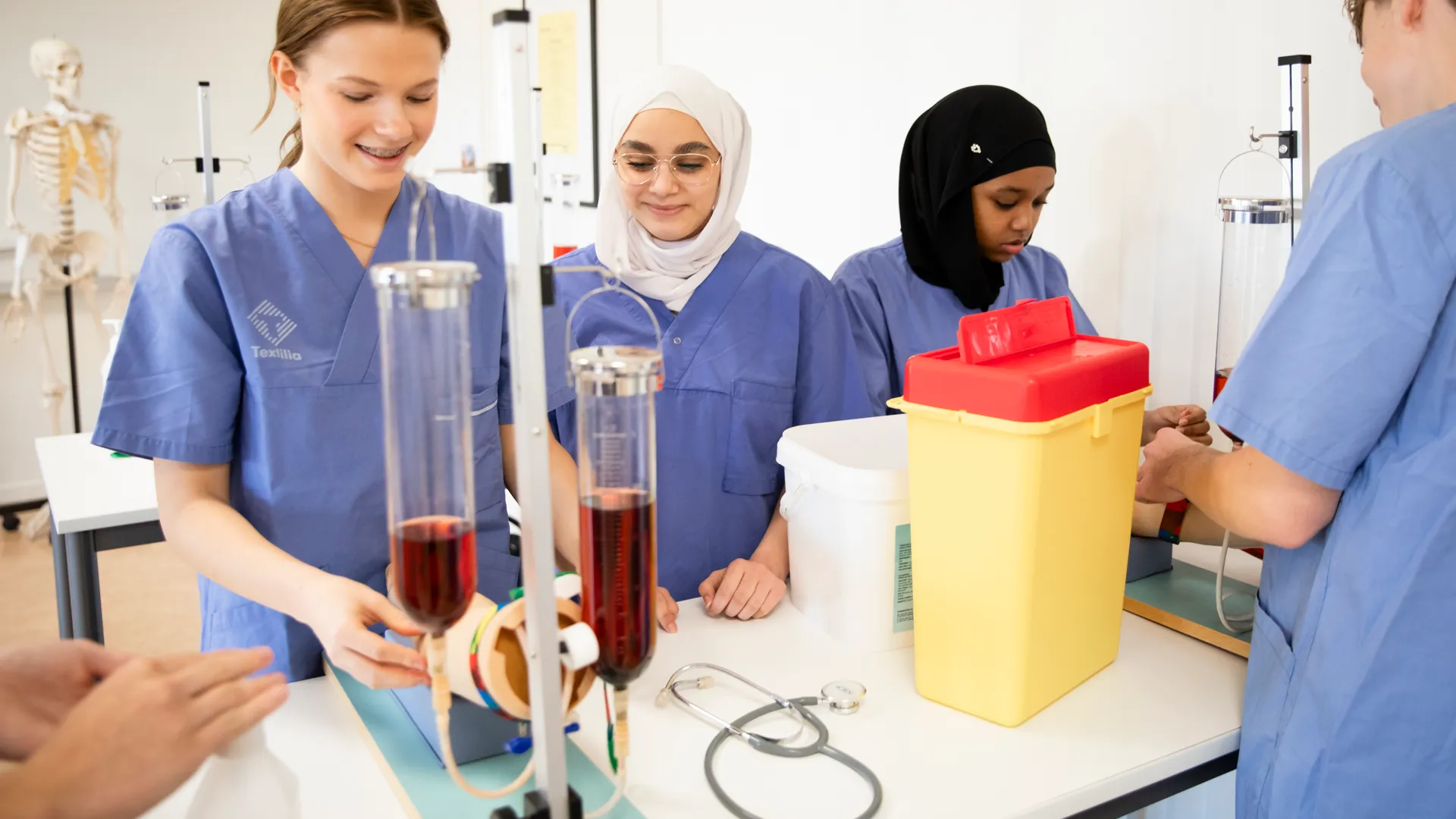 Gymnasieelever i blå vårdkläder.