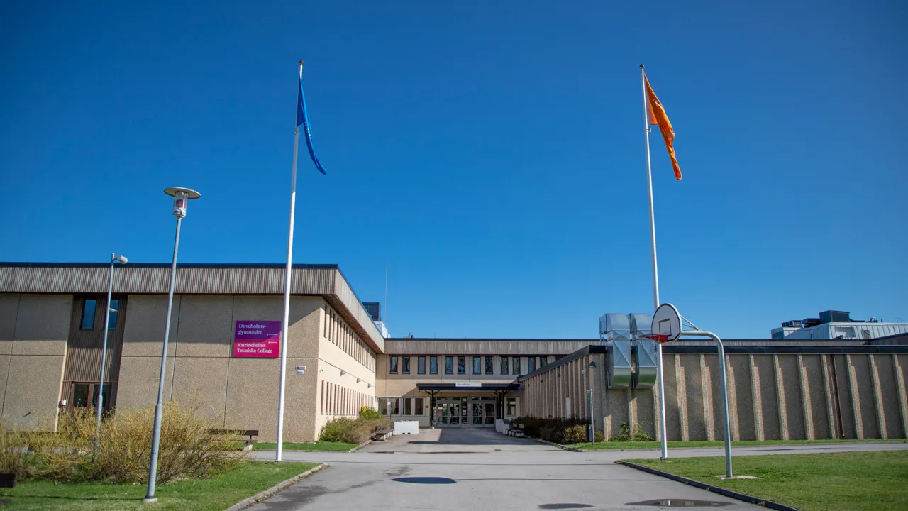 En stor byggnad med flaggor framför sig.