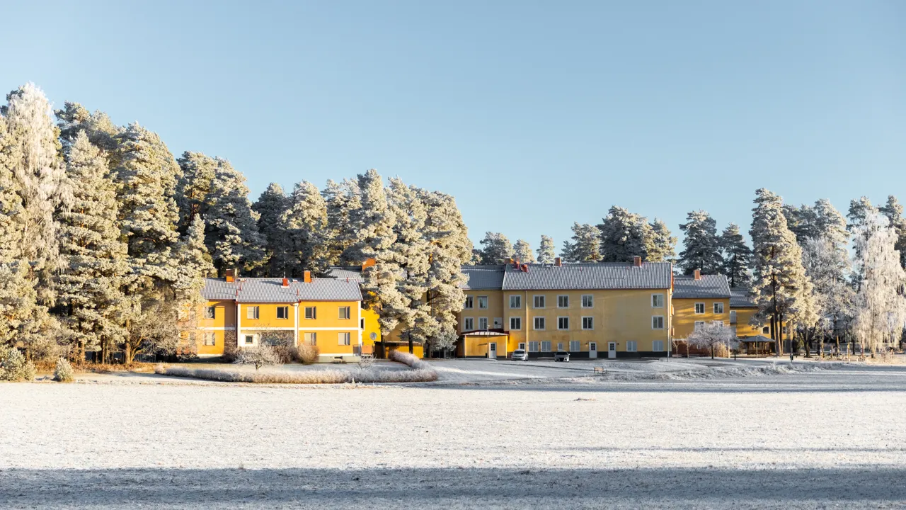 Ett gult hus mitt i ett snötäckt fält.