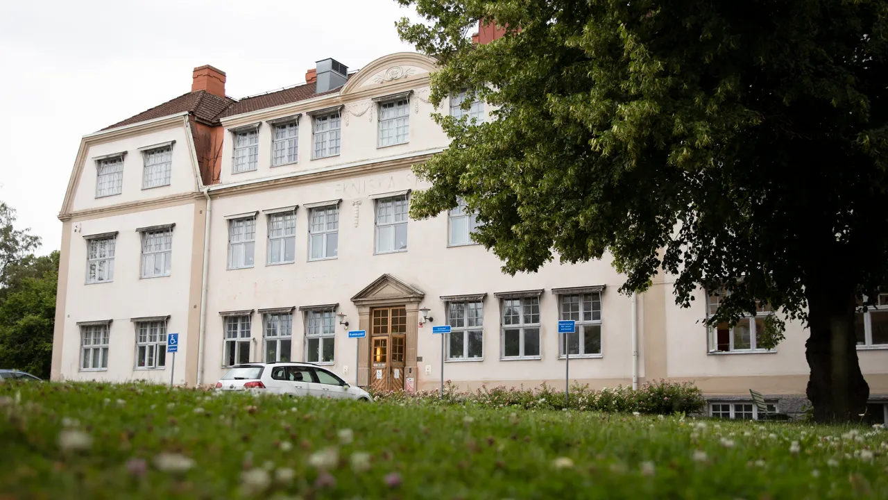 En stor vit byggnad med en bil parkerad framför.