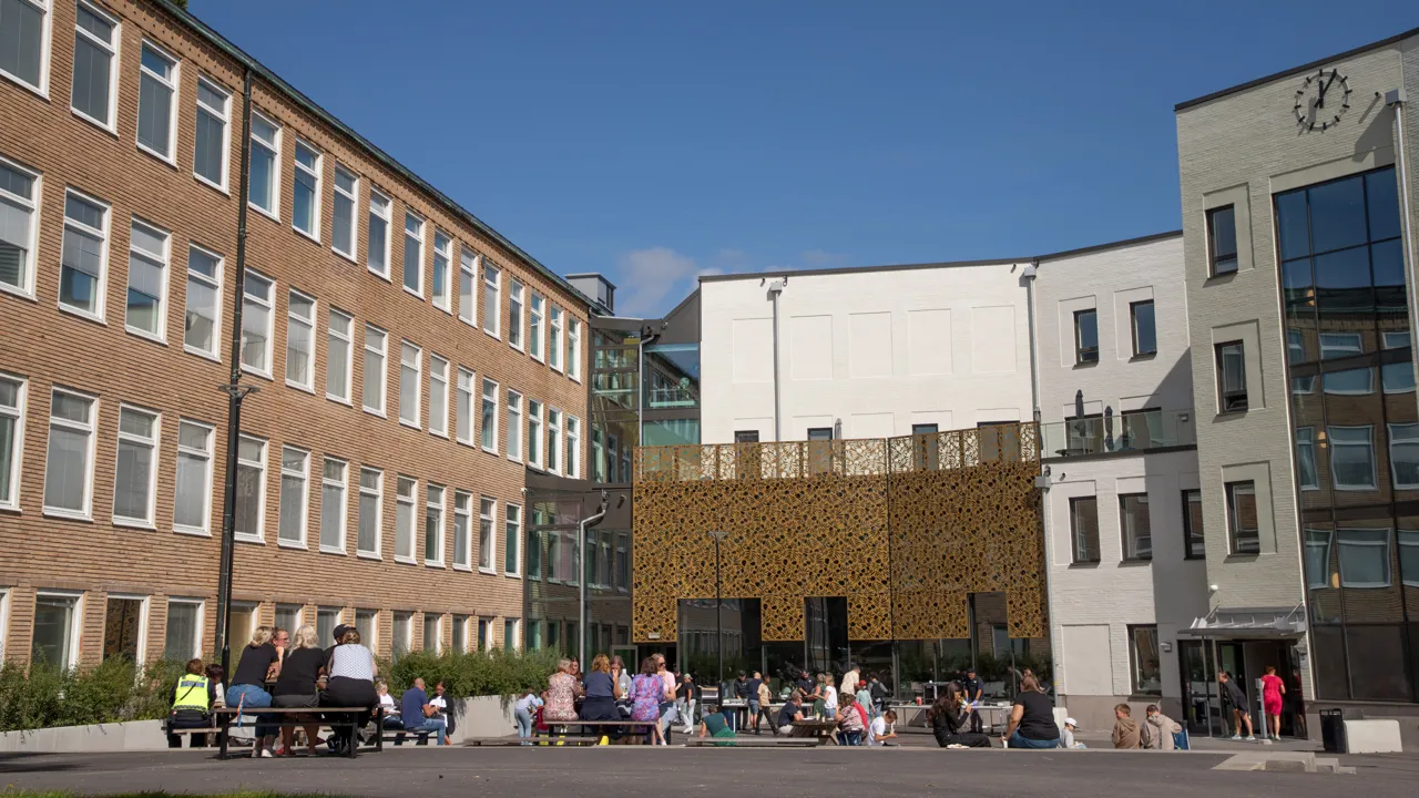 En grupp människor som sitter utanför en byggnad.