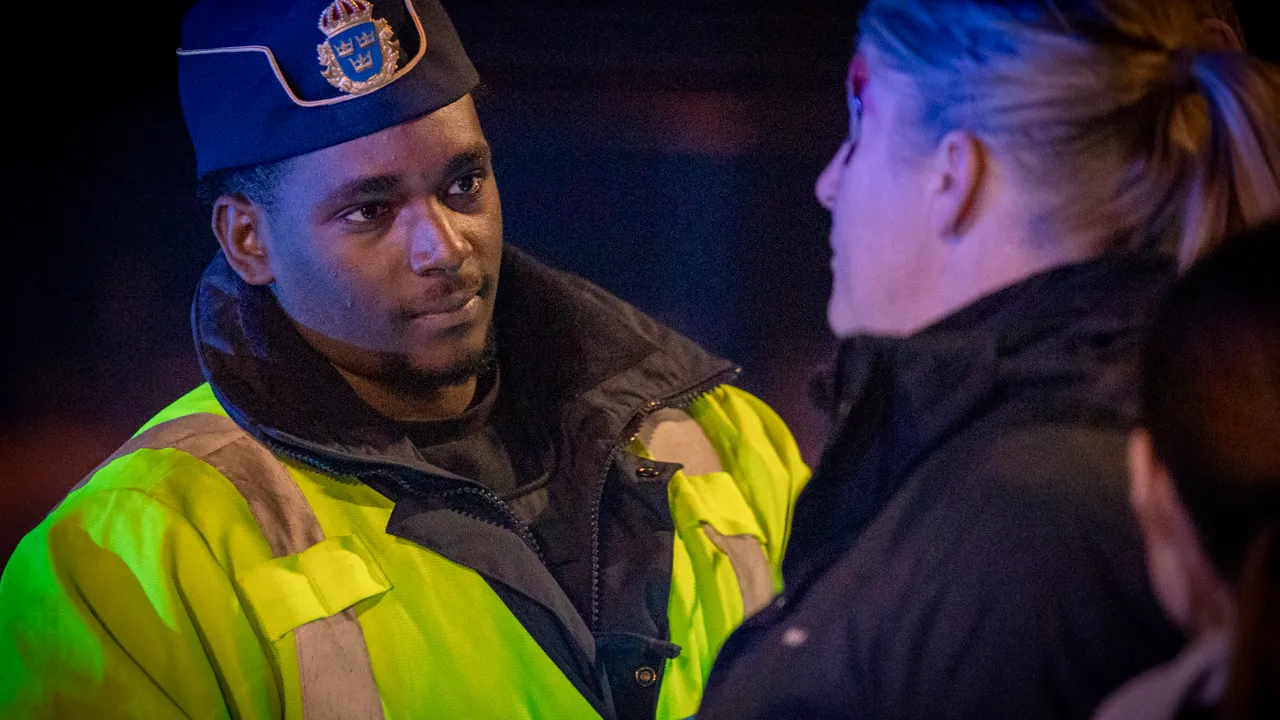 En polis som pratar med en kvinna.