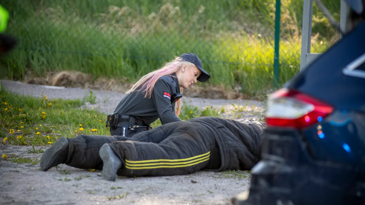 Person som sitter bredvid person som ligger på marken.