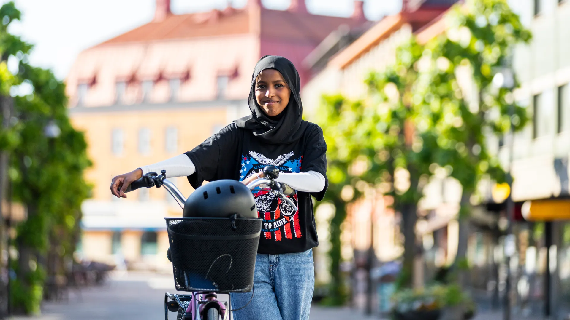 En kvinna som cyklar längs en gata.