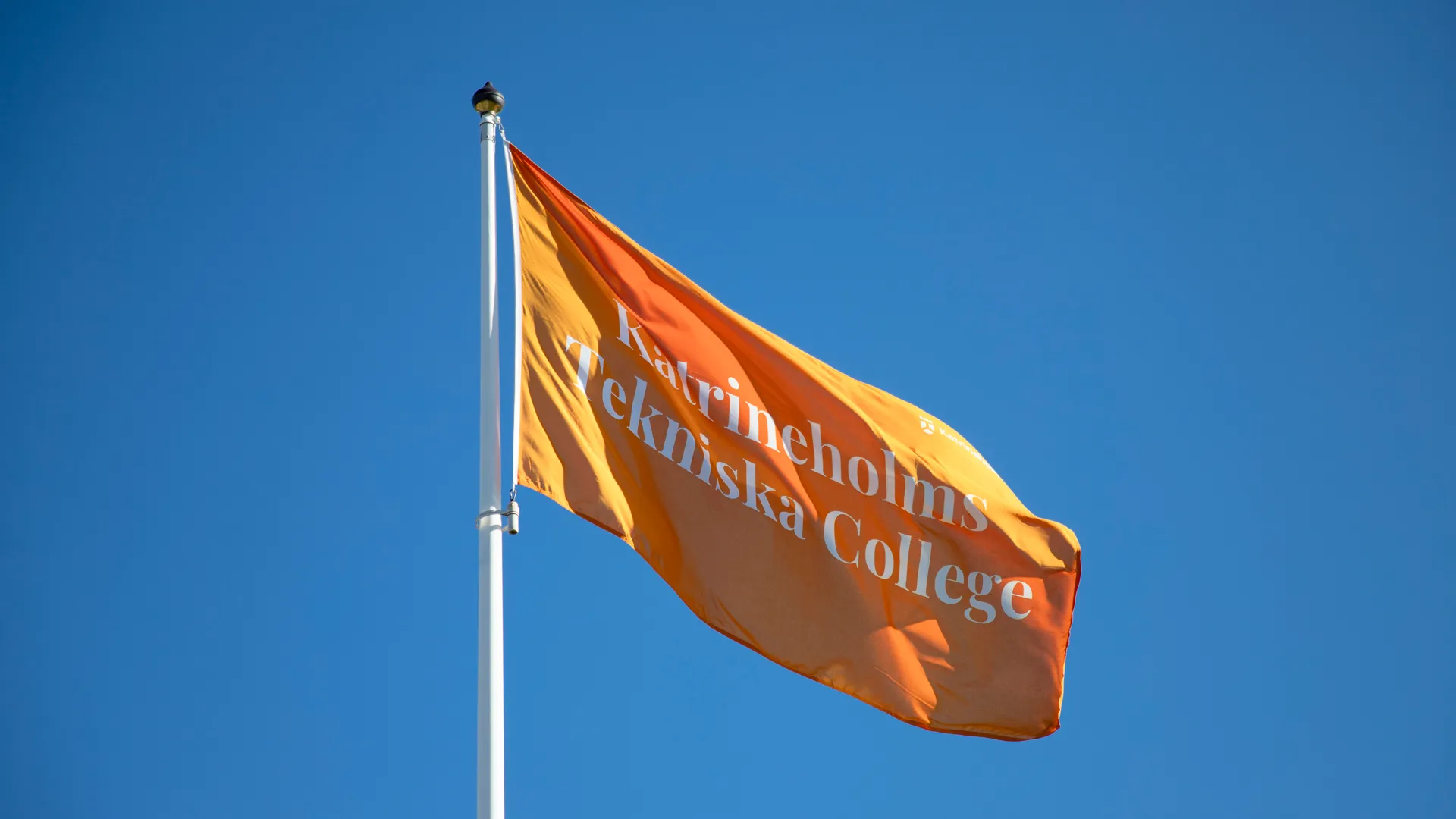 En orange flagga som vajar i vinden.