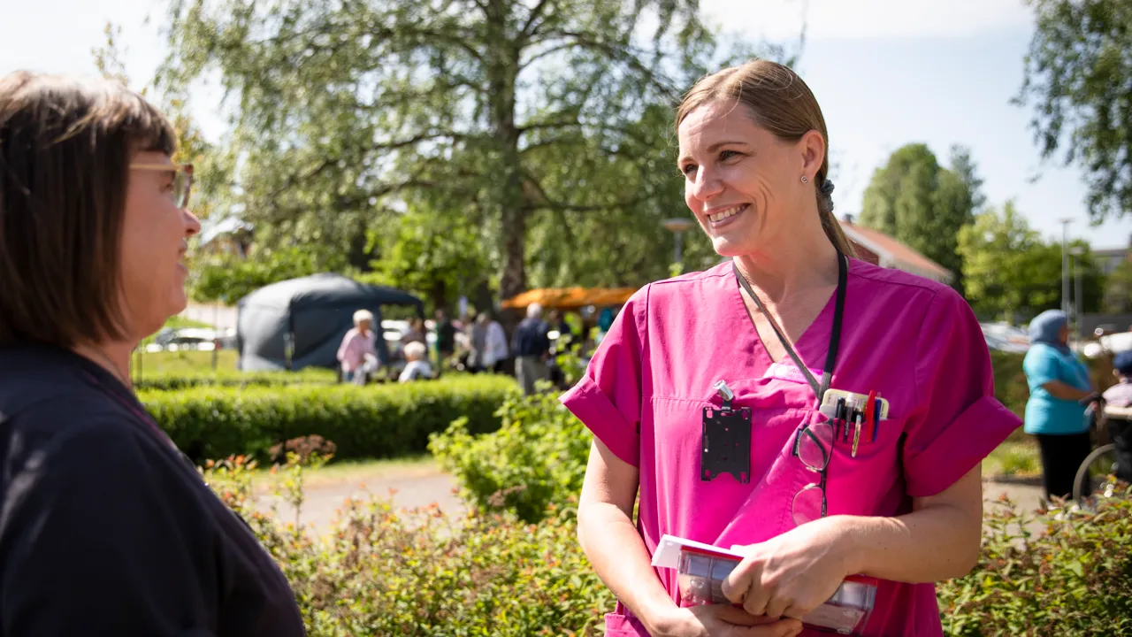 En kvinna i operationskläder som pratar med en annan kvinna i operationskläder.