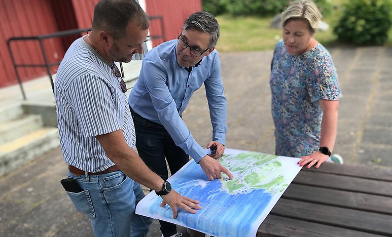Fredrik Ahlman (M), Johan Söderberg (S) och Anneli Hedberg (S) granskar förslaget på ansiktslyftning över Djulö camping. 