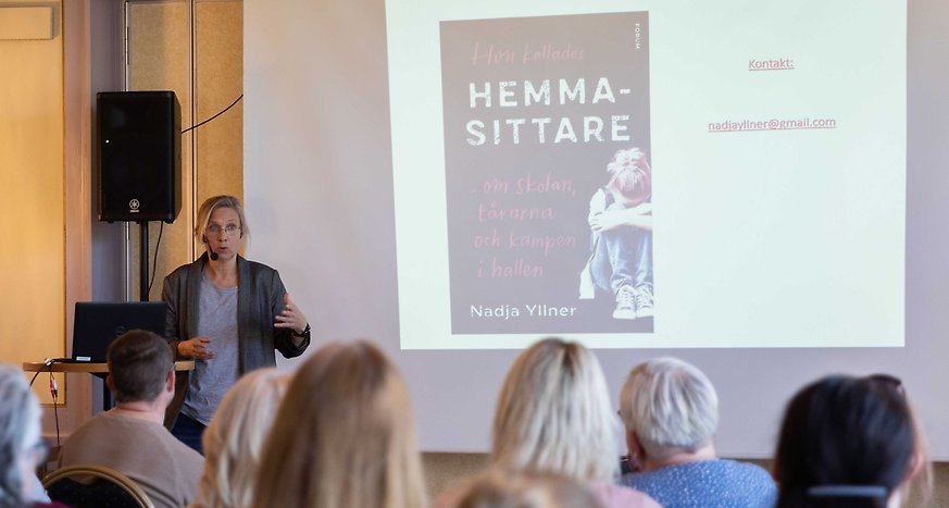 Nadja Yllner berättar om sin bok och visar en bild på boken på en powerpoint.