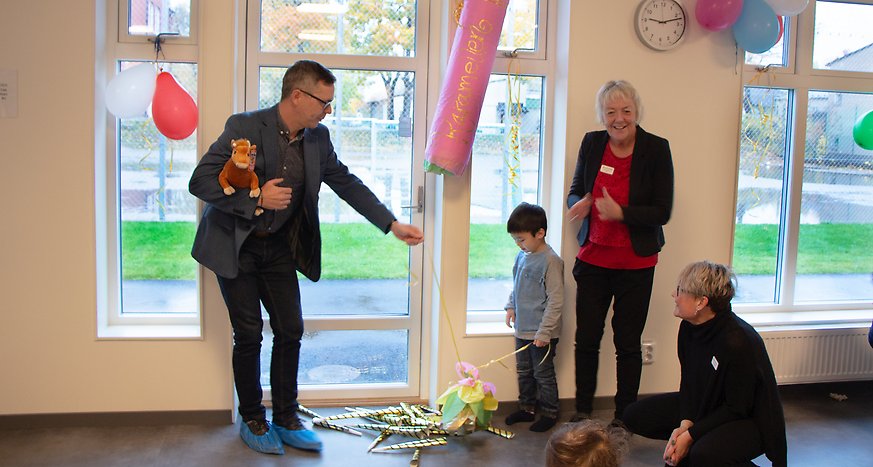 Bildningsnämndens ordförande Johan Söderberg tillsammans med fyraårige Hugo och rektor Bitte Larsson som dragit isär en stor smällkaramell för att inviga Karamellens förskola. 